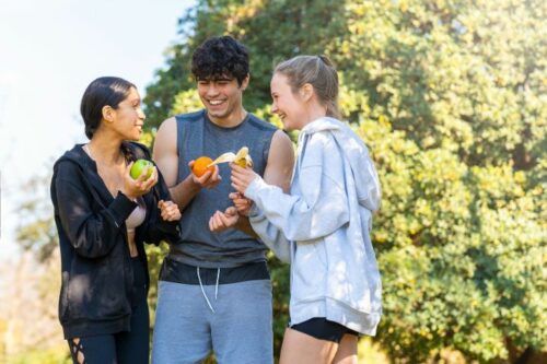 Groupe de jeunes qui sport une pause dans leur séance de sport pour manger des fruits