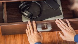 Personne qui enferme ses appareil mobile dans un tiroir