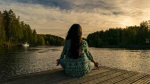 Femme qui médite au bord d'un lac