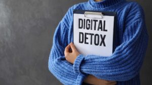 Femme qui tient un papier avec écrit "digital detox"
