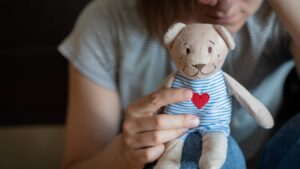 Femme avec une peluche dans les mains